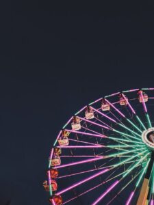 Colorful ferris wheel glowing in the night sky, capturing amusement park vibes.